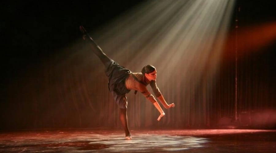 Ballet dancer performing under dramatic stage lighting