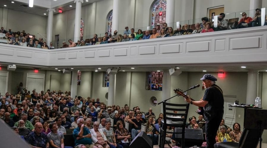 Musician performing for a packed church audience