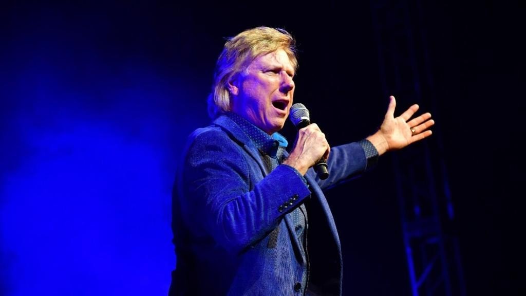Speaker performing on stage with blue lighting